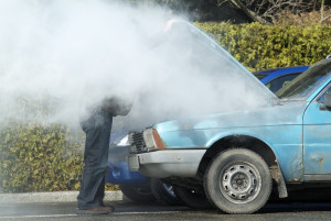 Man looking at a smoking engine in his car